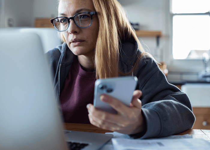 Woman using computer and phone